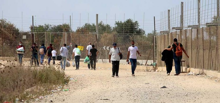 Palestinian workers enter and exit Israel through a gap in the Security Barrier.