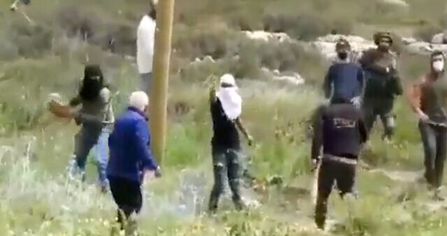Masked Jewish settlers assault a Palestinian farmer with stones in the occupied West Bank, Saturday April 3, 2021.
