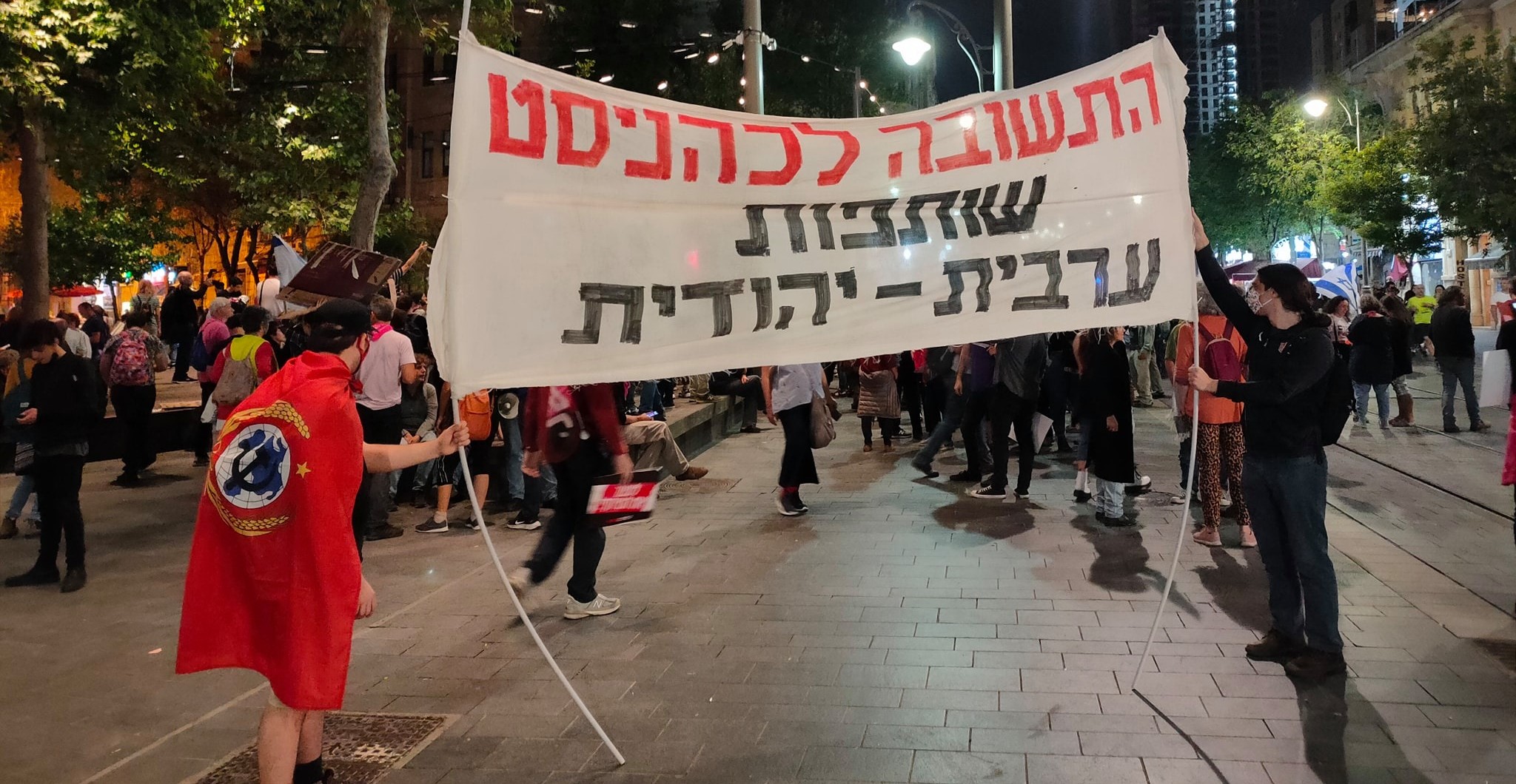 Young Communists demonstrate in West Jerusalem, Saturday night, April 24, 2021. The banner reads: "The answer to Cahanism is Arab-Jewish partnership."