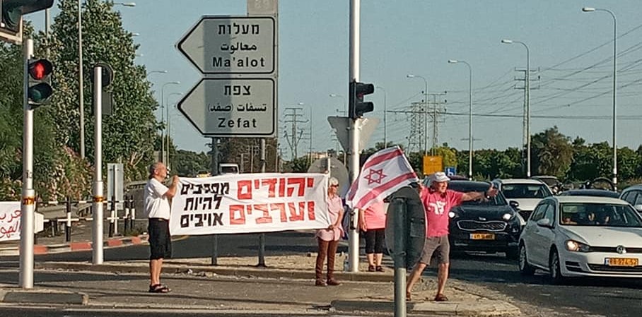 Demonstrators at the Kabri junction in Western Galilee, late Saturday afternoon, June 12; the large banner reads: "Jews and Arabs refuse to be enemies."
