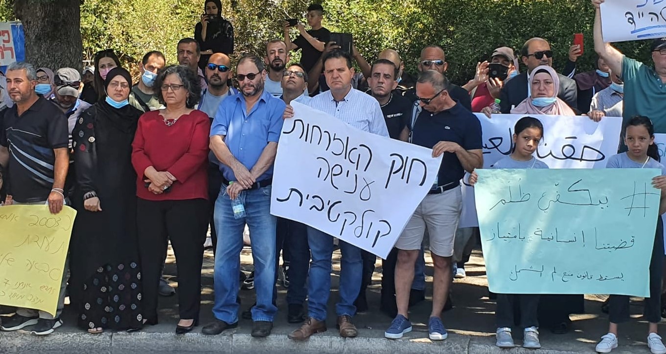 All three Hadash MKs, Aida Touma-Sliman, Ofer Cassif and Ayman Odeh (third to fifth from left), attend the rally against the renewal of the racist Citizenship Law that was held on Tuesday, June 29 outside the Knesset in Jerusalem. The white sign held by Odeh reads in Hebrew: "The Citizenship Law – Collective Punishment." The Arabic sign held by the two girls at the right reads "Enough injustice – Ours is a humanitarian cause par excellence – Down with the law preventing reunification!"