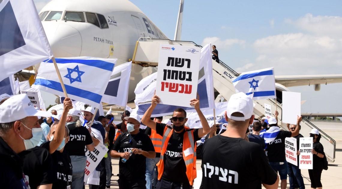 Aviation industry workers protest against government at Ben Gurion Airport, August 19, 2021. The uplifted sign demands "a security net now!"