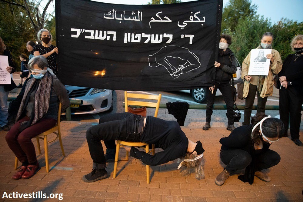 Israeli activists mark International Human Rights Day by demonstrating in front of the Tel Aviv offices of Israel's Internal Security Service (Shin Bet/Shabak) to protest political arrests of Palestinians, December 10, 2020. The black banner reads: "Enough of Shabak Rule."