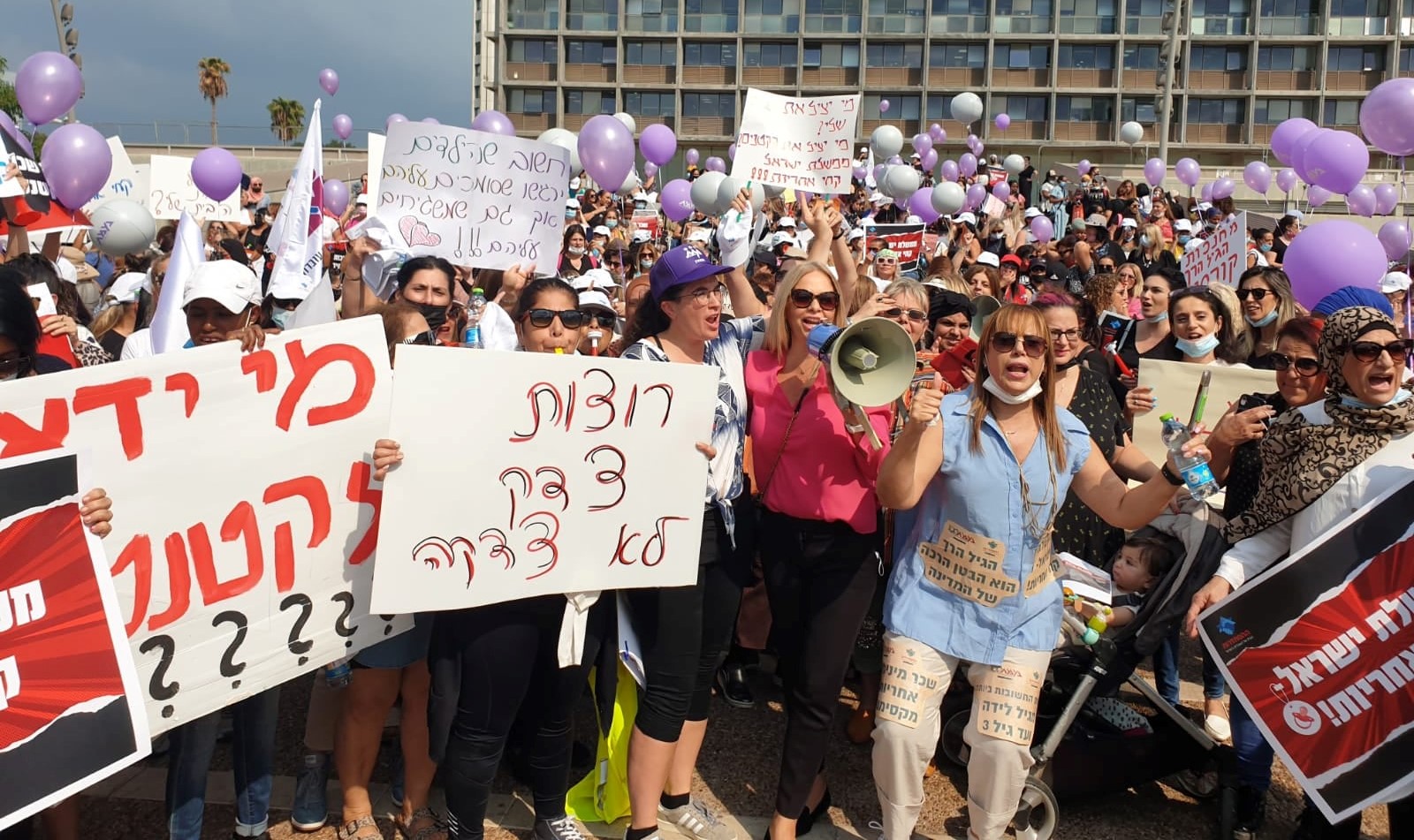 Thousands of striking daycare center workers protest in Rabin Square in central Tel Aviv, Sunday, October 3, with the launching of their open-ended strike. The placard in the center foreground reads "We want justice, not charity."