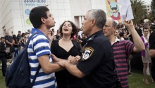 An policeman pushes an Im Tirzu right wing protester as he tries to attack participants in an event commemorating the Palestinian Nakba in Tel Aviv university, May 14, 2012 (Photo: Activestills)