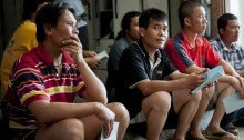 Thai workers sitting and listening on their rights by a Kav LaOved activist in Kfar Warburg (Photo: Activestills)