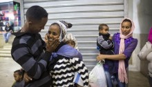 An Eritrean refugee hugs his wife and children, as they arrive to the central bus station in Tel Aviv on May 6, 2013, after they were released from the "Saharonim" Israeli prison (Photo: Activestills)