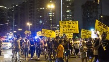 Residents of Givat Amal neighborhood in north Tel Aviv and supporters block a road during a protest against new luxury housing project planned to be built in the area and against the eviction of families, Tel Aviv, September 15, 2014 (Photo: Activestills)