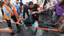 Palestinian men move the body of journalist, Rami Rayan, the victim of an Israeli air strike on a market place to an ambulance in the Shejaiya neighbourhood near Gaza City on July 30, 2014 (Photo: Ashraf Amra)