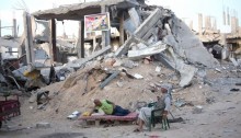 Palestinians sit in front of destroyed buildings in a quarter in At-Tuffah district of Gaza city, which was heavily attacked during the last Israeli offensive, Gaza city, September 21, 2014. During the seven-week Israeli military offensive, 2,131 Palestinians were killed, including 501 children, and an estimated 18,000 housing units have been either destroyed or severely damaged, leaving more than 110,000 people homeless (Photo: Activestills)