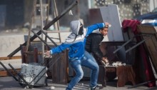 Palestinian youths throws stones during clashes with Israeli occupation forces at the Israeli Qalandia checkpoint between the West Bank city of Ramallah and Jerusalem on Friday, November 7, 2014 (Photo: Activestills)