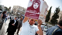 A Palestinian youngster holds aloft a poster of Hana Shalabi, during a rally near the Old City of Jerusalem on March 24, 2012. The demonstration took place in support of the imprisoned Shalabi, who was conducting a hunger strike at the time, in protest for her administrative detention by Israel.