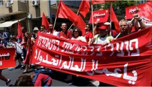 MKs Dov Khenin and Aida Touma-Sliman (Hadash - Joint List), leading the May Day March in Tel-Aviv on Friday, May 1. On the banner is written, in Hebrew and Arabic: “Workers of All Lands Unite!”