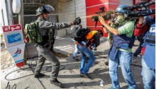A member of Israel’s Border Police assaults journalists and medics assembled near Al Bireh, West Bank, October 30, 2015.