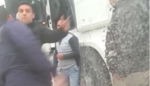 The police officer who assaulted the truck driver Mazen Shwiki (center background) now attacks a bystander who intervened on the latter’s behalf.
