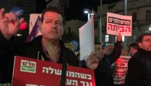 A demonstrator participating in last Saturday night’s anti-corruption protest in Tel Aviv carries one of Hadash’s anti-government placards: “When the government is against the people, the people are against the government.”