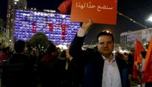 MK Ayman Odeh during a demonstration against the murder of women in Tel-Aviv, December 4, 2018; the sign he holds aloft reads: "We will put an end to this."