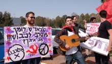 Roman Levin (with guitar) and comrades demonstrate outside the military base at Beit Naballah. The Hebrew placard to the left reads: "Tbarish ('Friend' ['Comrade'] in Russian), Roman rejects the occupation!!! What about you?"