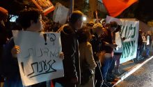 Hundreds of Israeli and Palestinian activists demonstrate close to Prime Minister Benjamin Netanyahu's official residence on Saturday night, December 7, in solidarity with the residents of Issawiya. The large banner beneath red flag in the right of the photograph reads: “We are all with Issawiya”; the placard to the left proclaims: "Enough of the racist policy."