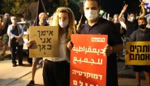 MK Ayman Odeh holds a Hadash placard that reads in Arabic and Hebrew "Democracy for all" during the anti-government protest in Paris Square, near the PM’s official residence, on Saturday night, August 22. The women protester next to Odeh holds a sign in Hebrew reading "Ayman, I'm here."