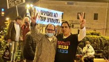 Hadash MK Ofer Cassif (Joint List, left) and leading protest activist Sadi Ben-Shitrit demonstrate near the official residence of the prime minister in Jerusalem’s Paris Square, Saturday evening, February 13, calling for Netanyahu’s resignation. The banner held up in the background reads “We no longer believe this evil regime!”