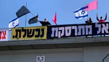 Anti-Netanyahu protestors demonstrate from atop a highway overpass near Hadera, Saturday, May 29, 2021. The banners read: "Israel is crashing" and "You have failed."