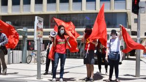 Oren Feld (second from left, holding a mobile phone in his right hand) brandishes a red flag during a May Day rally in Jerusalem, May 1, 2020.
